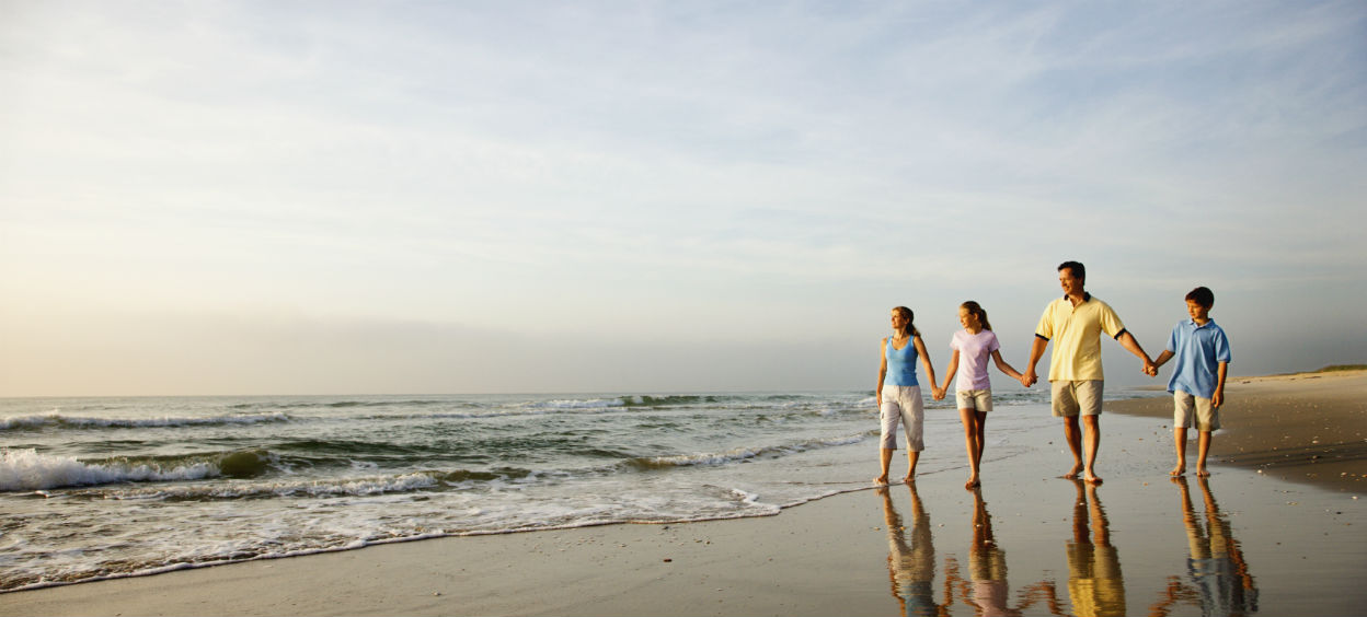 Famille qui marche ensemble sur la plage